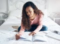 Study, learning and student bedroom bed work of a black woman studying for a university exam. Home working, college book Royalty Free Stock Photo
