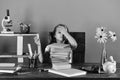 Study room and back to school concept. Girl with ashamed face holds green clock. Kid and school supplies on green wall Royalty Free Stock Photo