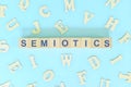 Study semiotics in linguistics concept. Wooden blocks word typography flat lay in blue background. Royalty Free Stock Photo