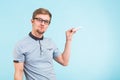 Study, students, university and college concept - Young funny man holds chalk isolated on blue background.