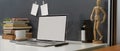 Study table with mock up laptop, stack of books and decorations on white desk Royalty Free Stock Photo