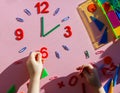 Study the topic of hours with children. The watch is made of numbers, paper clips, and sticks from a children learning kit