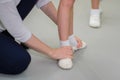 Studying ballet. Foot basic first position training. Teacher corrects ballerinas pose, closeup view of hands and feets.
