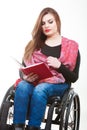 Young disabled woman in wheelchair with book. Royalty Free Stock Photo