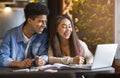 Studying students sitting in comfortable cafe, using laptop Royalty Free Stock Photo