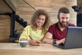 Studying students sitting in comfortable cafe, using laptop. Royalty Free Stock Photo