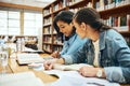 Studying together can sometimes be easier. two young female university students studying in the library. Royalty Free Stock Photo