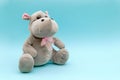 Stuffed animal hippo on blue background. Child soft toy, comforter for sleep.