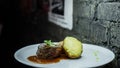 Stuffed baked potatoes with grilled meat and barbecue sauce and greens on the table in the bar. Wonderful delicious lunch.