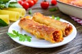 Stuffed cannelloni with bechamel sauce. Cannelloni pasta baked with meat, cream sauce, cheese on a wooden background Royalty Free Stock Photo