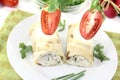 Stuffed cheese crepe rolls with tomatoes