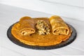 Stuffed crepes with minced chicken meat, mushrooms and marinated cucumber. Thin pancakes with filling. Side view Royalty Free Stock Photo