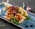 Stuffed crepes topped with tofu cheese, pesto sauce and arugula on plate