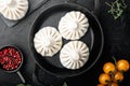 Stuffed dumplings, manti of dough and minced , in frying cast iron pan, on black stone background, top view flat lay, with copy