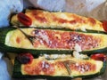 Stuffed green zucchini with cheese and eggs seasoned with grated cheese pepper rosemary and chily tomatoes baked in the oven