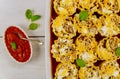 Stuffed lasagna rolls in oven tray with tomato sauce