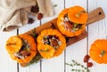 Stuffed fall mini pumpkins with rice, cranberries, cabbage and nuts over white wood