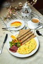 Stuffed Omelette with bown bread, meat, vegetable salad include tomato, potato, lettuce leaf and carrot with tea, coffee, and Royalty Free Stock Photo