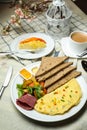 Stuffed Omelette with bown bread, meat, vegetable salad include tomato, potato, lettuce leaf and carrot with tea, coffee, and Royalty Free Stock Photo