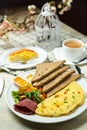 Stuffed Omelette with bown bread, meat, vegetable salad include tomato, potato, lettuce leaf and carrot with tea, coffee, and Royalty Free Stock Photo