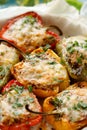 Stuffed peppers, halves of peppers stuffed with bulgur, dried tomatoes, herbs and cheese in a baking dish ,close-up,