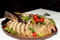 Stuffed pike on a plate of vegetables and leaves of green salad Royalty Free Stock Photo