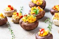 Stuffed portobello mushrooms with bulgur, vegetables and aromatic herbs on concrete background. Vegetarian food