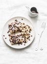 Stuffed ricotta cheese crepes with chocolate sauce, bananas and nuts on a light background