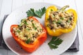 Stuffed sweet peppers with rice mushrooms and cheese with herbs. Baked halves of red and yellow peppers with filling Royalty Free Stock Photo