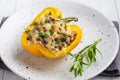 Stuffed sweet peppers with rice mushrooms and cheese with herbs. Baked halves of yellow peppers with filling. White Royalty Free Stock Photo