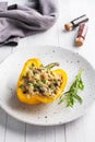 Stuffed sweet peppers with rice mushrooms and cheese with herbs. Baked halves of yellow peppers with filling. White wooden Royalty Free Stock Photo