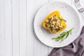 Stuffed sweet peppers with rice mushrooms and cheese with herbs. Baked halves of yellow peppers with filling. White Royalty Free Stock Photo