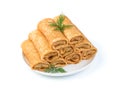 Stuffed thin pancakes in a white plate with dill. Side view, close-up.