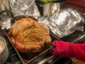 Stuffed turkey in roasting pan with aluminum foil and red hot mitt Royalty Free Stock Photo