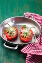 Stuffed vegetarian or vegan filled red paprika or bell pepper with spelt or brown rice and vegetables with cheese and fresh basil Royalty Free Stock Photo