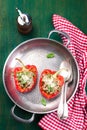 Stuffed vegetarian or vegan filled red paprika or bell pepper with spelt or brown rice and vegetables with cheese and fresh basil Royalty Free Stock Photo
