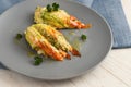 stuffed zucchini or courgette blossoms baked with parmesan cheese and parsley garnish on a blue gray plate Royalty Free Stock Photo