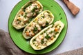 Stuffed zucchini with turkey, tomato, cheese and spring onion on a green plate Royalty Free Stock Photo