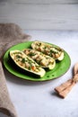 Stuffed zucchini with turkey, tomato, cheese and spring onion on a green plate Royalty Free Stock Photo