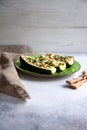 Stuffed zucchini with turkey, tomato, cheese and spring onion on a green plate Royalty Free Stock Photo