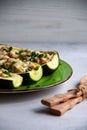 Stuffed zucchini with turkey, tomato, cheese and spring onion on a green plate Royalty Free Stock Photo