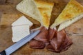 Stuffing focaccia bread with  italian smoked speck ham and taleggio cheese on a wooden cutting board Royalty Free Stock Photo