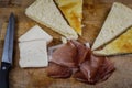 Stuffing focaccia bread with  italian smoked speck ham and taleggio cheese on a wooden cutting board Royalty Free Stock Photo