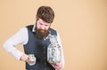 Stuffing some cash into his pockets. Bearded man hiding away cash holdings. Businessman taking cash money out of glass Royalty Free Stock Photo