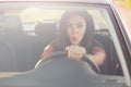 Stunned beautiful brunnette female drives car with shocked expression, sees something awful on road, keeps hand on wheel. View fro Royalty Free Stock Photo