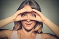 Stunned curious woman, peeking looking through fingers like binoculars Royalty Free Stock Photo