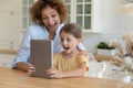 Amazed mom and little daughter feel shocked using tablet