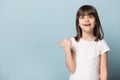 Stunned little girl looks at camera point finger on copyspace Royalty Free Stock Photo