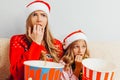 Stunned mother and her little daughter, dressed in Santa Claus h