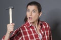 Stunned 30s woman holding hammer for self-defense or DIY Royalty Free Stock Photo